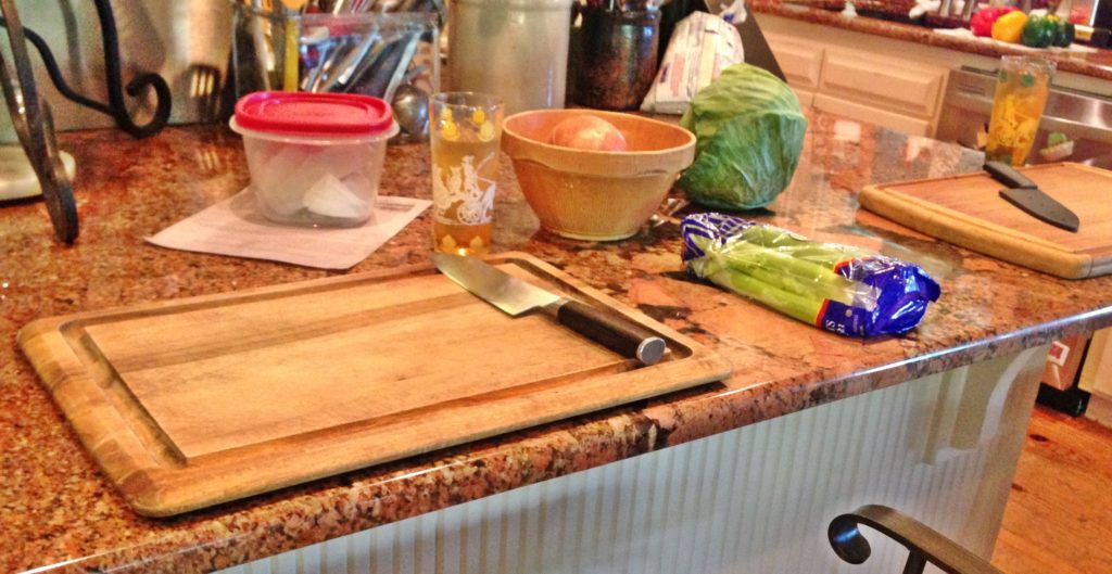 www.diningwithmimi.com Old Southern Rice Dressing Recipe Photo of two cutting boards. sweet tea glasses. cabbage on large granite counter