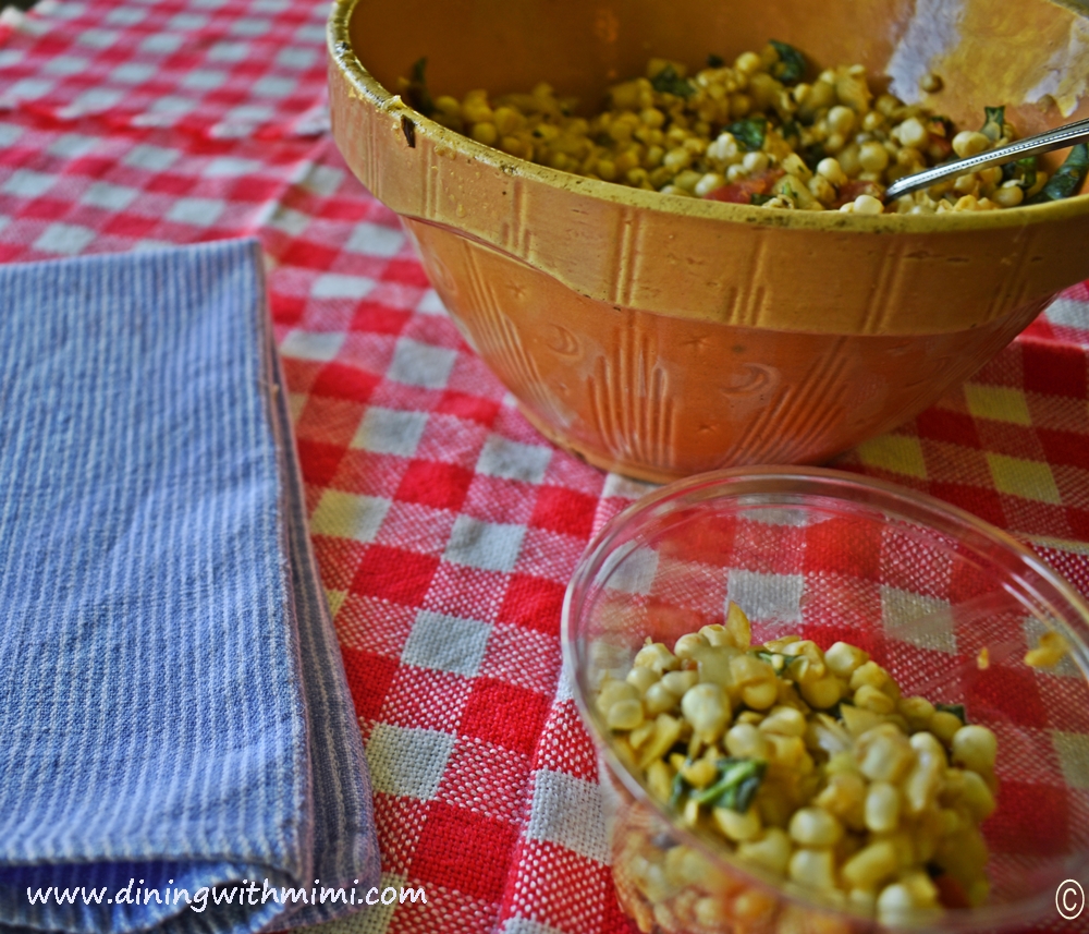 Red and white tablecloth, blue denim napkin, vintage bowl of Picnic Worthy Roasted Poblano Corn Salad www.diningwithmimi.com