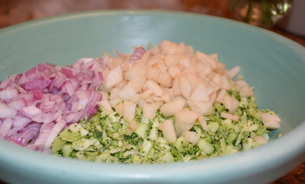 Turquoise Roseville Pottery bowl loaded with fresh chopped broccoli, red onions and pears www.diningwithmimi.com